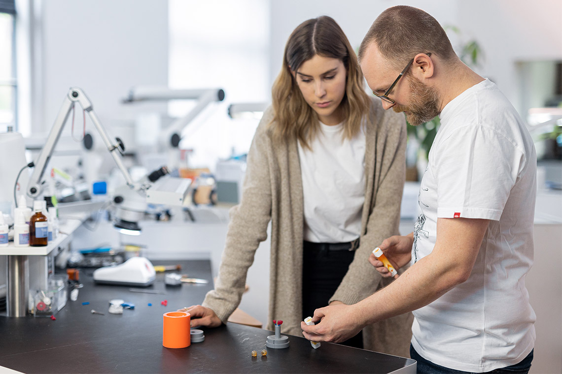 Two dental technicians discussing VITA AMBRIA Press Ceramic