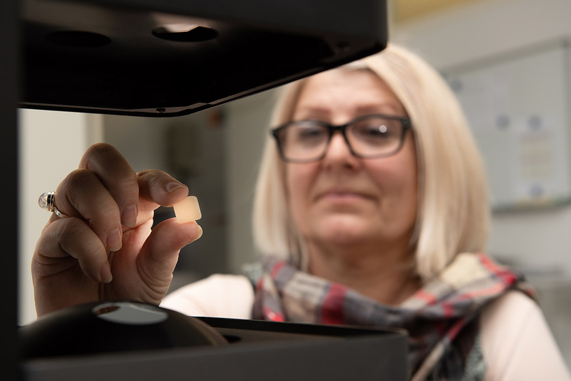 Un campione colore in ceramica pressabile viene misurato da una collaboratrice VITA Mitarbeiterin