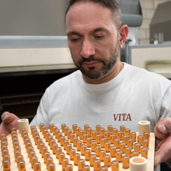 VITA Mitarbeiter mit VITA AMBRIA Presskeramik Pellets nach der Kristallisation