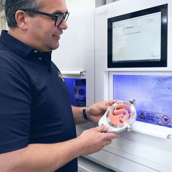 A denture base made of VITA VIONIC BASE is taken out of the milling machine.