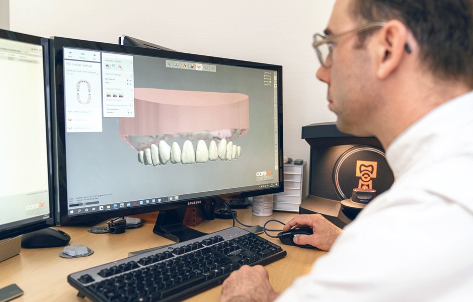 Dental technician Okke Kamps checks the virtual set-up of the teeth on the computer.