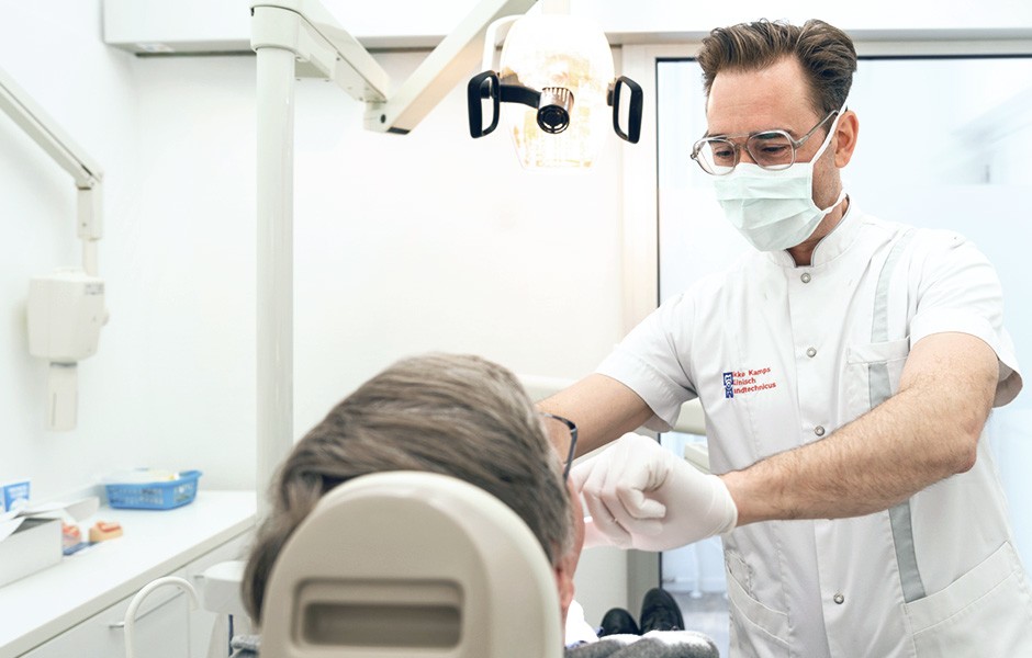 Le prothésiste dentaire Okke Kamps et un patient lors de l'essai d'une prothèse