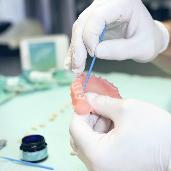 Aplicación del sistema adhesivo VITA VIONIC BOND en las cavidades de una base de prótesis.