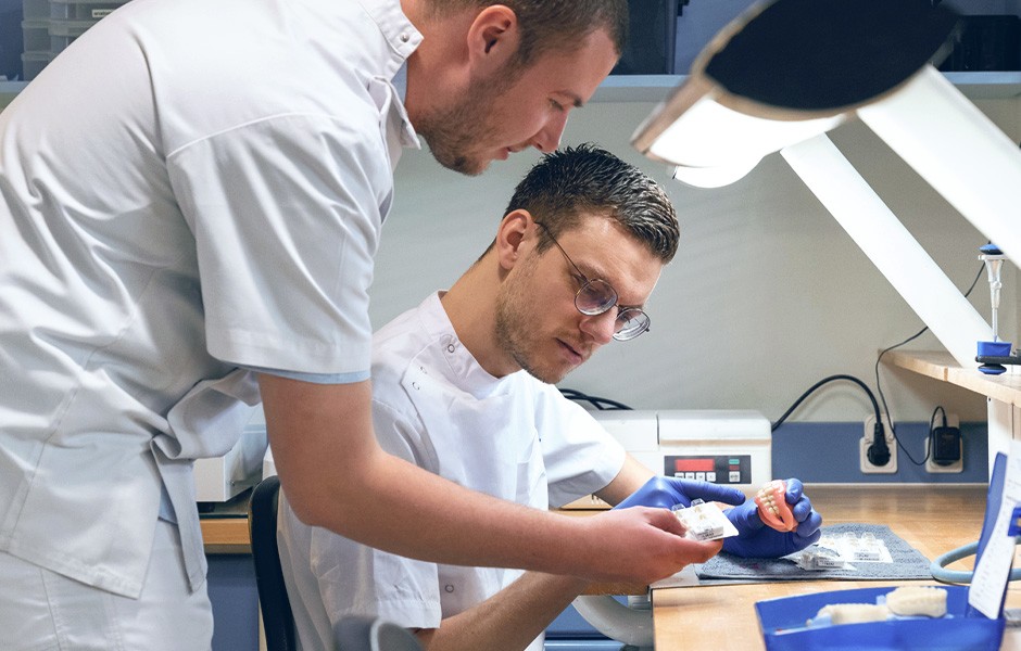 Two dental technicians working on a digitally fabricated denture