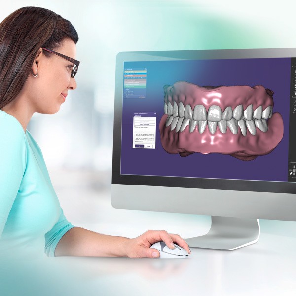 A dental technician designs a denture in the CAD system